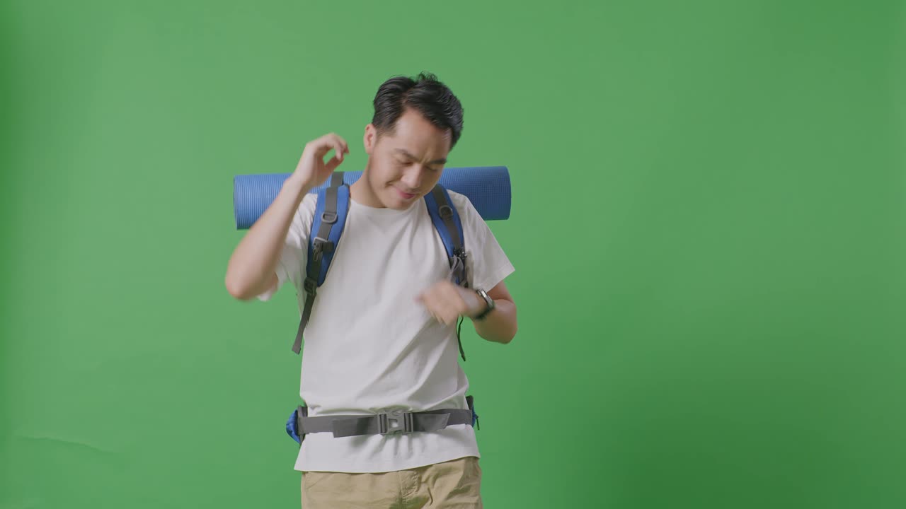 초록색 스크린 앞에 포즈를 취하는 배을 가진 남자