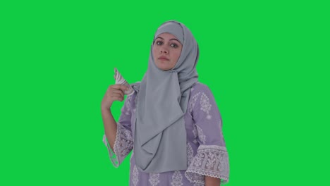 serious muslim woman money as fan green screen