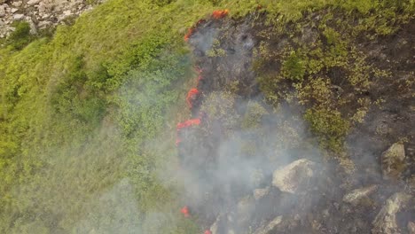 ojo de pájaro aéreo volando sobre el fuego en la montaña en un día de viento