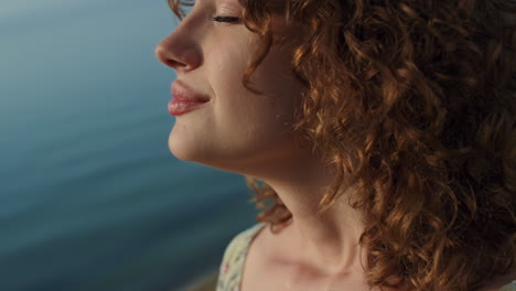 portrait beautiful woman smiling on beach. cute girl raising face to sunlight.