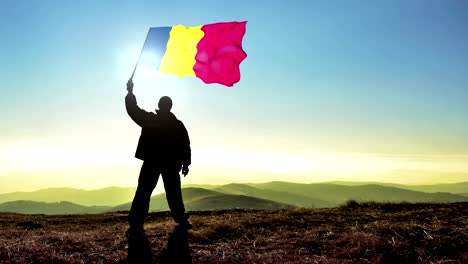 successful silhouette man winner waving chad flag on top of the mountain peak. cinemagraph loop background