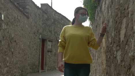 caucasian, millennial woman with protection mask discovers new places at lake garda, italy