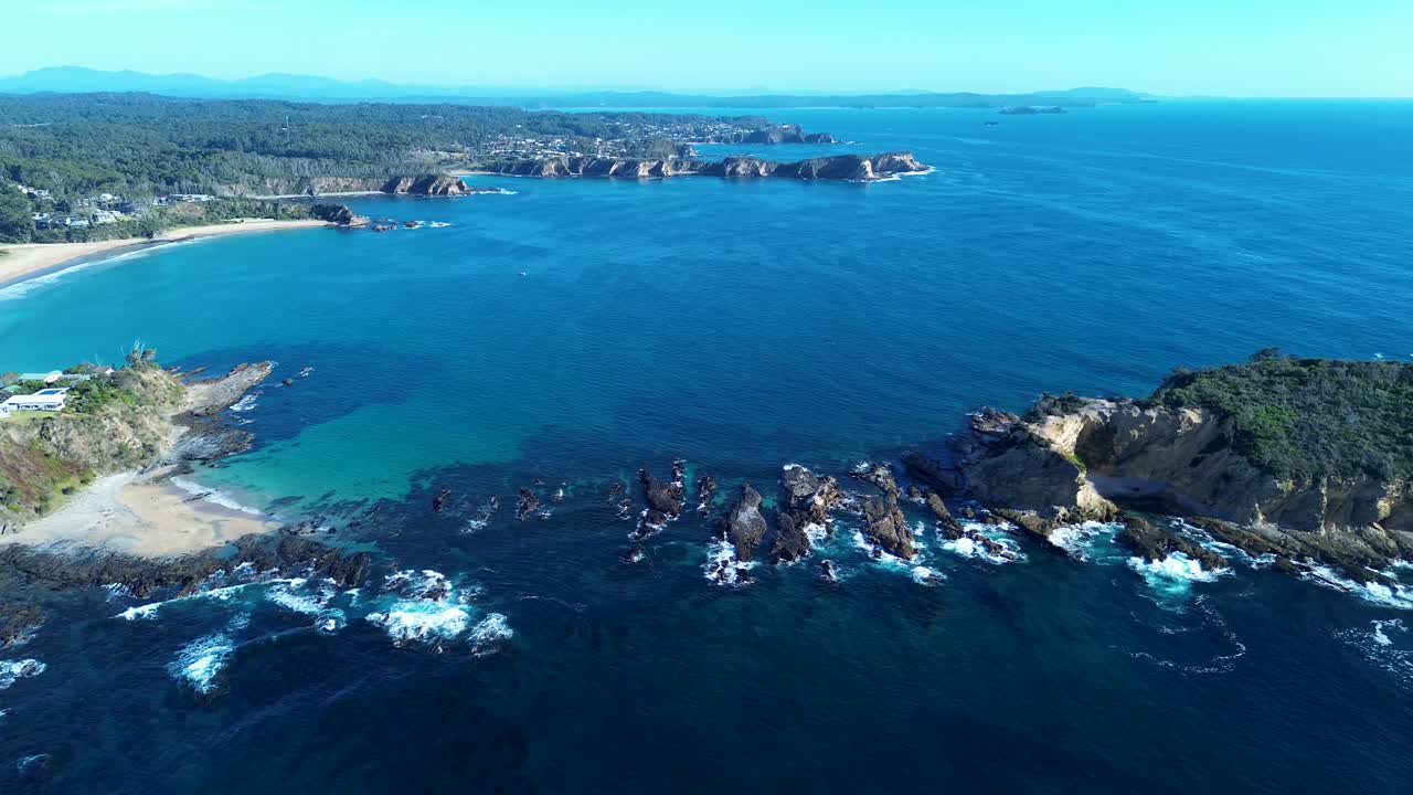 Paesaggio aereo con drone della pittoresca spiaggia di Rosedale e del promontorio roccioso di Jimmies Island con case rurali e boscaglia lungo la costa di Malua Bay, nella regione di South Coast, Australia: viaggi, turismo e natura