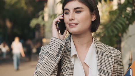 una mujer elegante haciendo una llamada de negocios al aire libre.