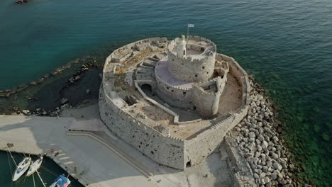 An-aerial-city-view-of-Rhodes-island-in-Greece-containing-clips-of-the-medieval-old-town,-the-old-lighthouse-at-the-port,-old-windmills,-beaches-and-amazing-sunset