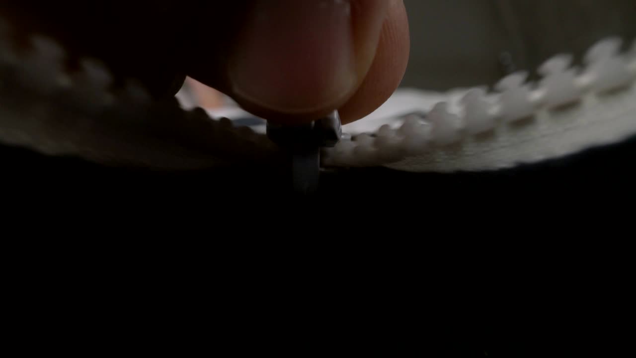 extremo cierre con la mano abriendo la cremallera de la chaqueta del suéter.