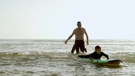 Happy-father-helping-son-swimming-on-board