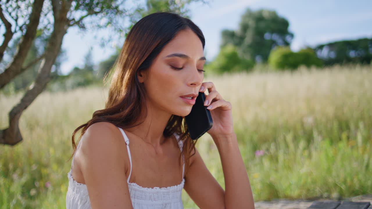Rural model cellphone call sitting tree place closeup. Serious woman talking