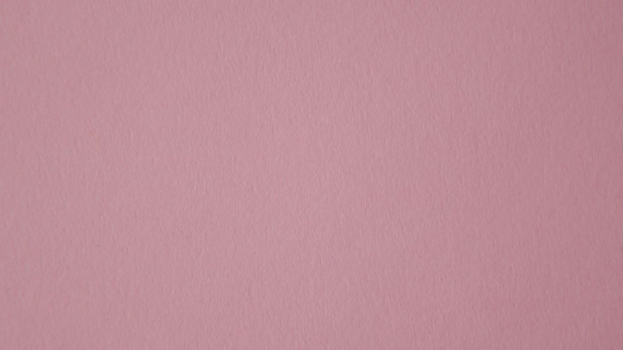 mano recogiendo dulces de corazón con un mensaje de ser feliz sobre fondo rosa