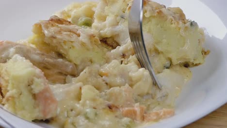 close slow motion shot of eating fish pie from a bowl