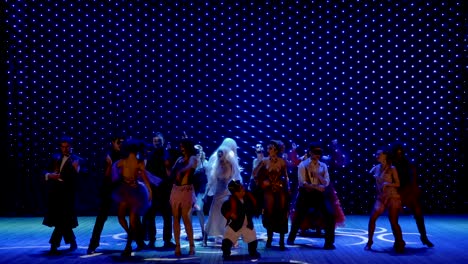 personas extraordinarias en trajes escénicos están bailando en el escenario del teatro