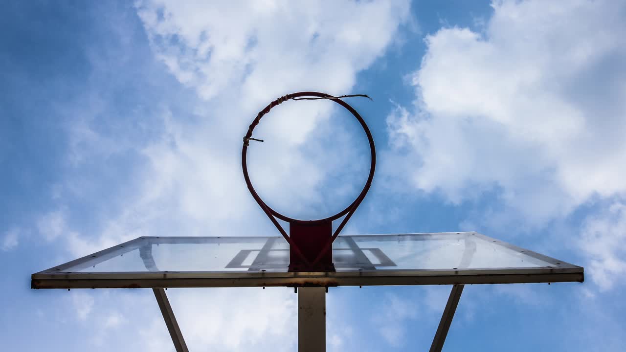 un aro de baloncesto con un fondo de nubes en movimiento