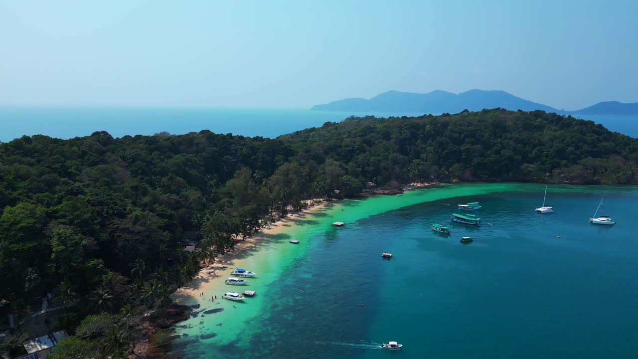 Koh Wai Bay Beach with boats anchored in turquoise waters. Fantastic aerial view flight ascending drone