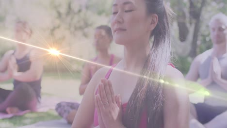 animation of light spots over diverse women practicing yoga and meditating