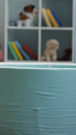 little kids run and gather balls throwing into dry pool in living room. brother and sister clean apartment space from toys at home closeup