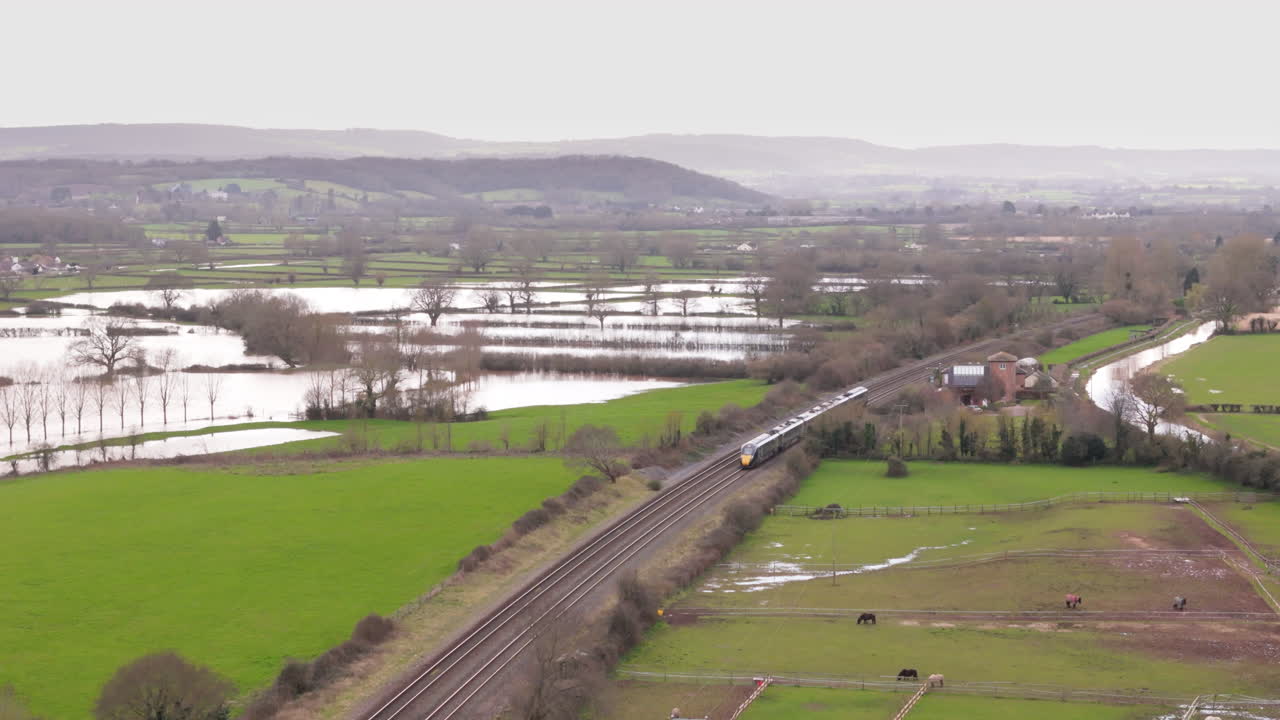 el tren de bristol a plymouth pasa por el campo inundado en somerset, reino unido.
