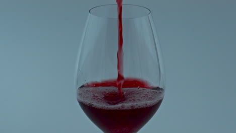 clear gourmet liquor flowing down wineglass closeup. red wine streaming in glass