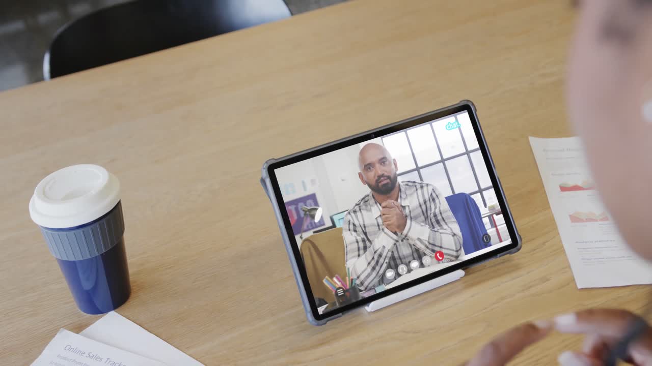 mujer de negocios caucásica en una videollamada con un colega afroamericano en la pantalla