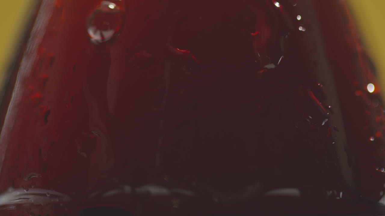 Close Up Of Condensation Droplets Running Down Bottle Of Cold Beer Or Soft Drink Against Yellow Background