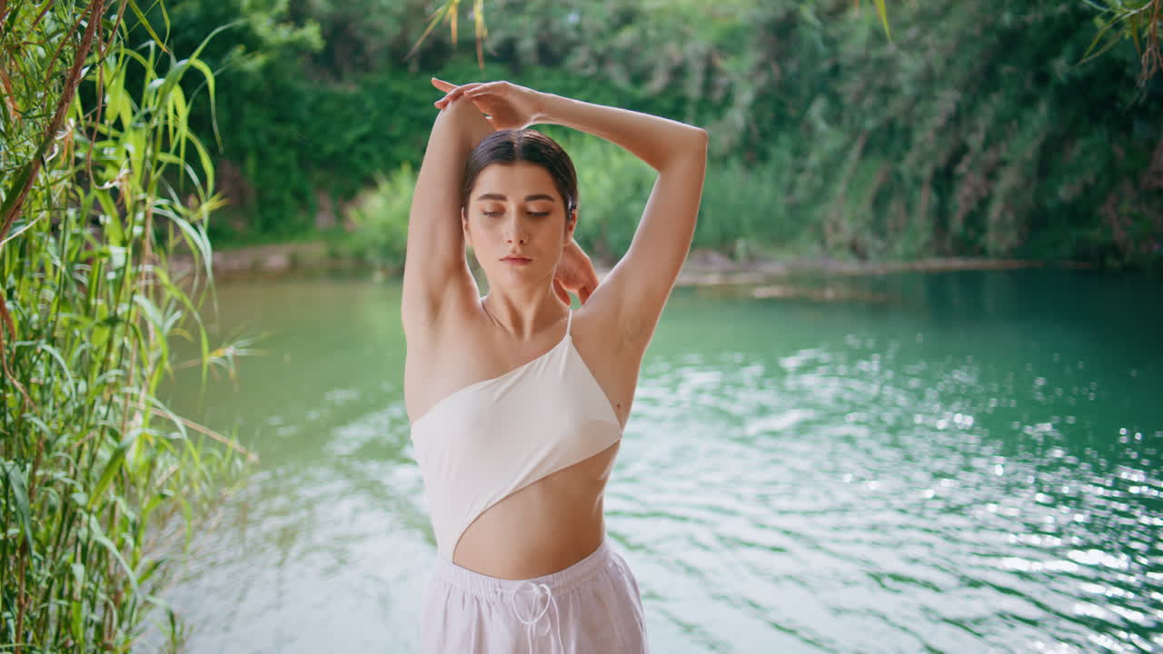 열대 연못 장소 클로즈업에서  옷을 입고 혼자 훈련하는 여성에 초점을 맞습니다.