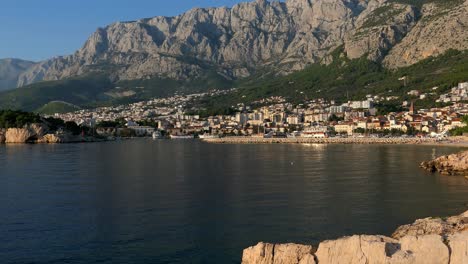 ciudad costera costera por montañas dramáticas, disparo ascendente, makarska, croacia