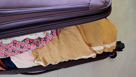 opened purple suitcase with clothes