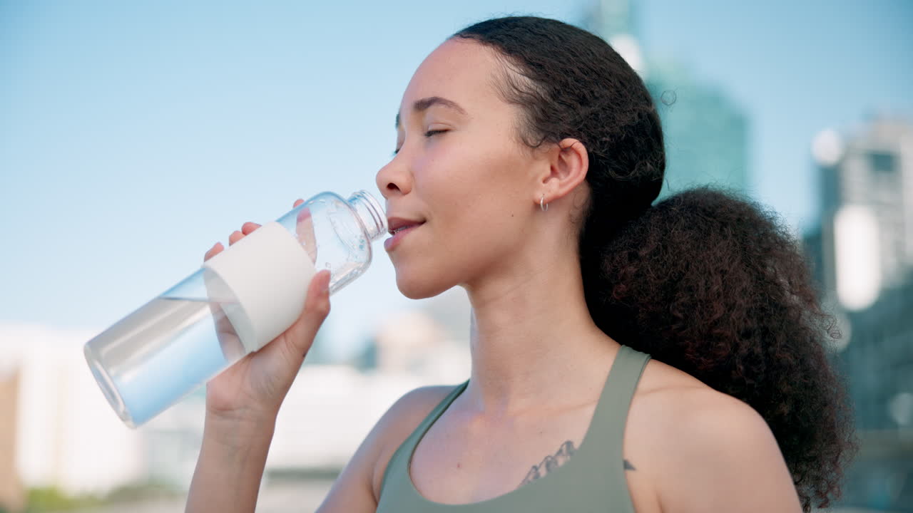City, fitness and woman drinking water