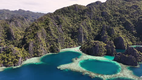 stunning drone footage of coron island, philippines, featuring its crystal-clear lagoons, sandy beaches, and lush forested landscapes. revealing aerial shot.