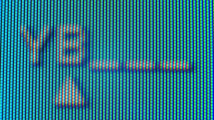 Pixels in the working old analog TV screen close up. Red, blue and green dot create the image on the screen. Analogue retro TV settings menu in extreme close up