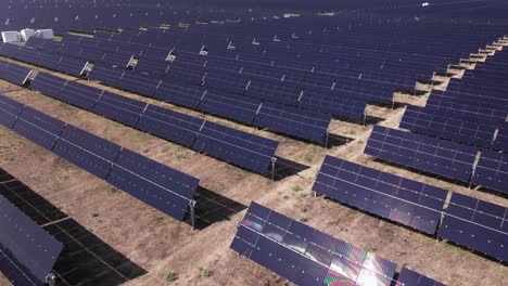 large solar panel farm in a dry open landscape with clear skies viewed from above