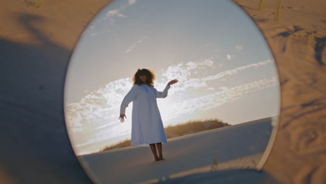 mirror reflecting woman dance at sand desert in front sunset. girl performance.