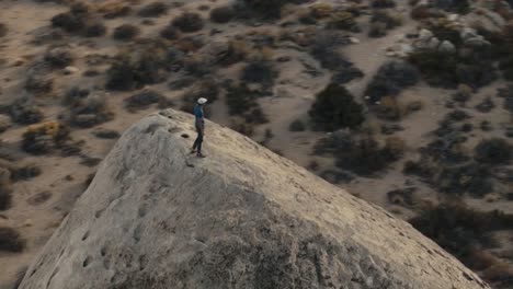 Rock-climber-on-giant-boulder,-Buttermilks-near-Bishop-orbital-aerial