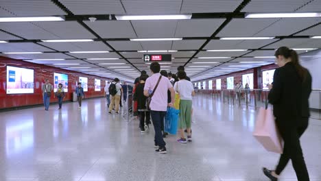 passengers walking through the concourse of the mass transit railway. handheld static wide shot