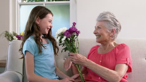 granddaughter offering flowers to her grandmother