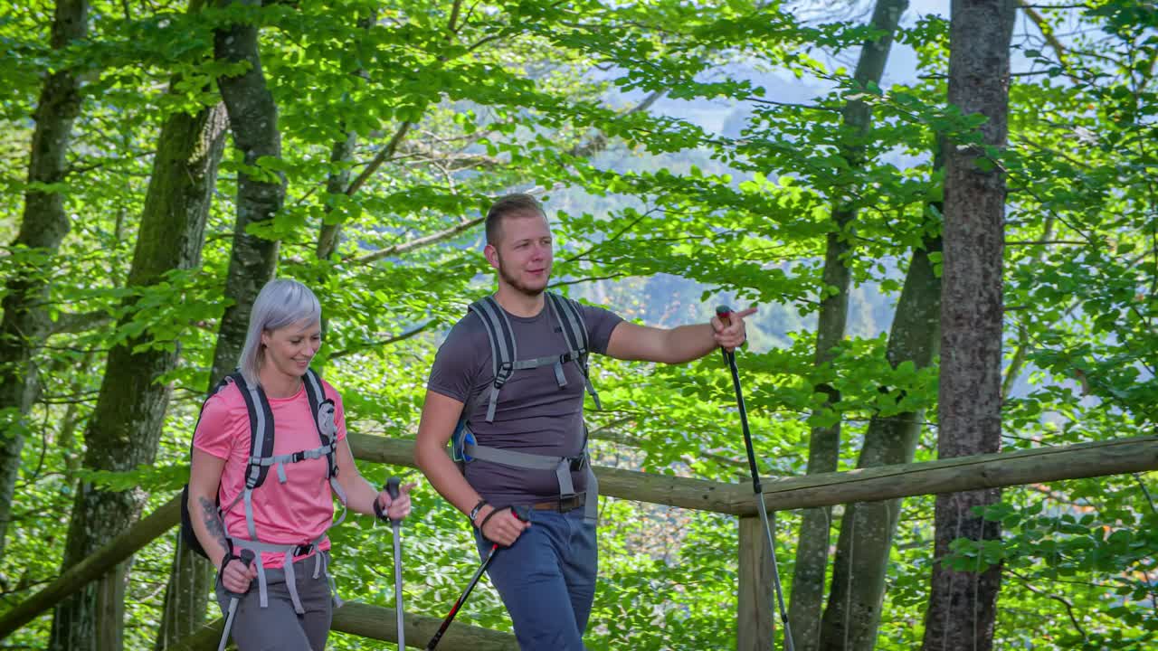Married Caucasian Couple Hiking With Trekking Poles Through National Park