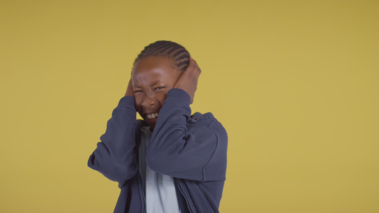 Studio Portrait Of Young Boy On ASD Spectrum Showing Sensitivity To Loud Noises Or Sounds 1