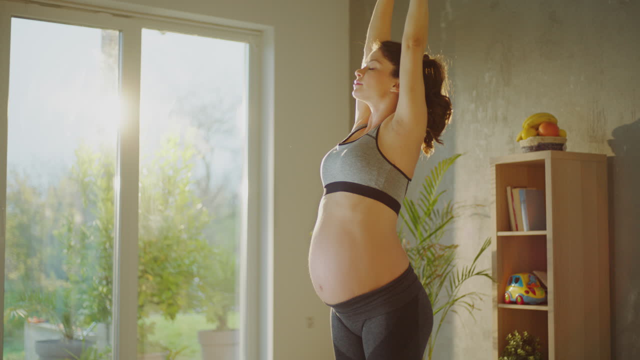 mujer embarazada estirándose en casa