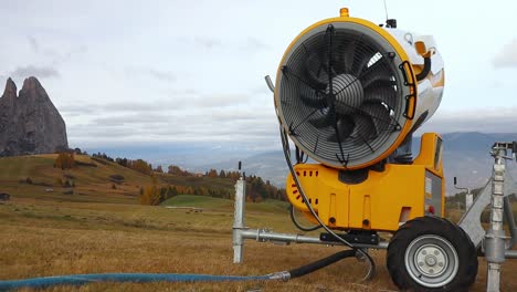 snow cannon fan spins freely in the wind out of season in the alpine mountains in italy