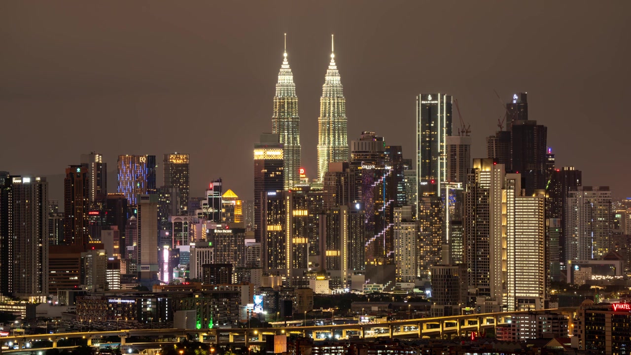 Timelapse de Día a Noche de la Metrópolis de Malasia, Puesta de Sol Dramática y Nublada. KLCC al Fondo