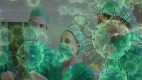 Animation-Von-Covid-19-Zellen-über-Verschiedenen-Chirurgen,-Die-Gesichtsmasken-Im-Operationssaal-Tragen