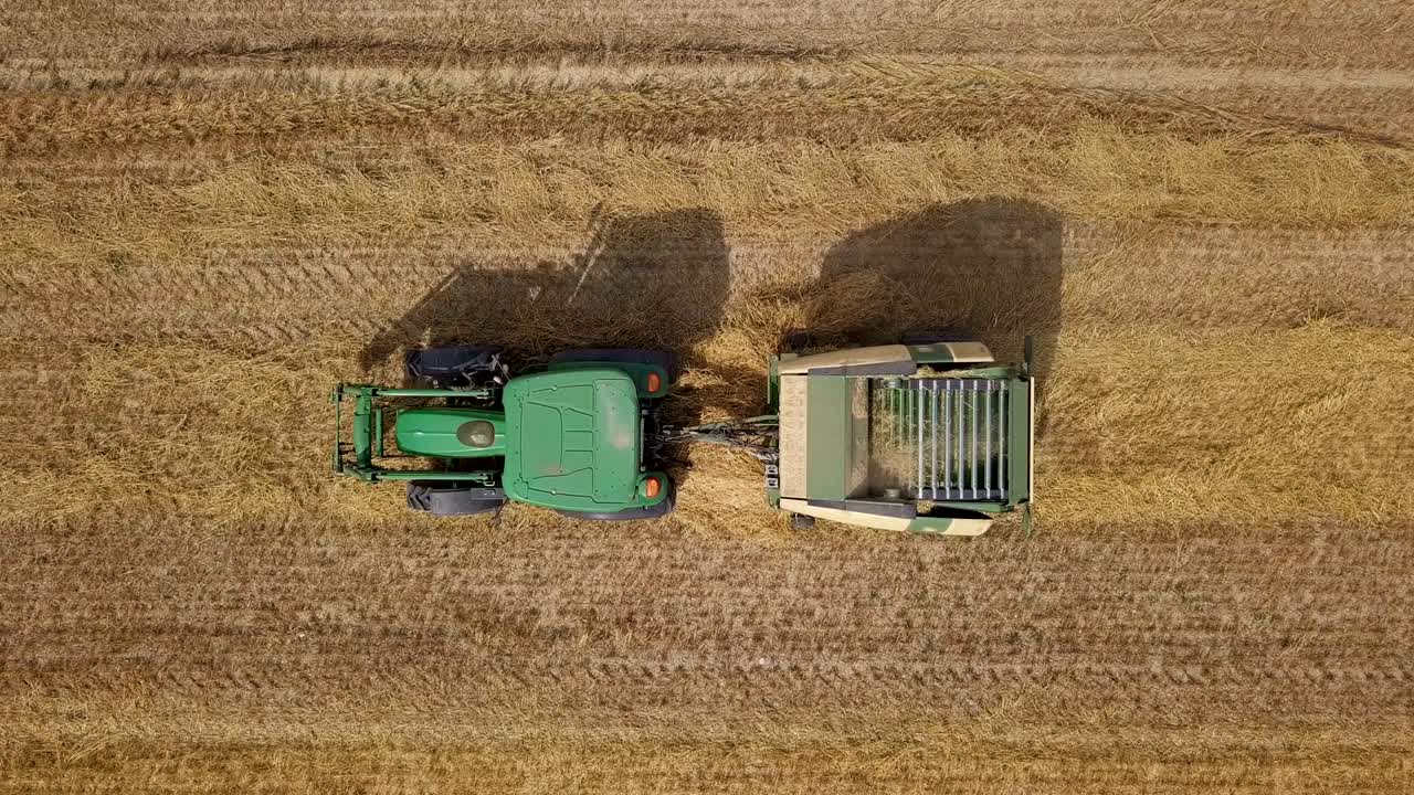 vista aérea de arriba de un tractor empacador de heno trabajando en el campo