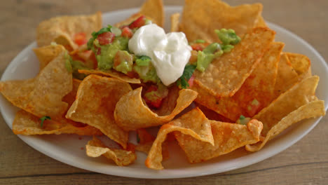 mexican nachos tortilla chips with jalapeno, guacamole, tomatoes salsa and dip