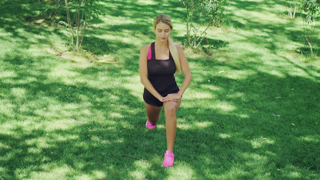 Donna sportiva che fa stretching prima dell'allenamento di corsa all'aperto. Ragazza in forma che fa squat.