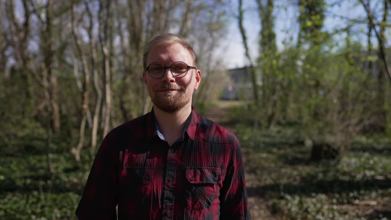 Confident, Smiling Man Walks Towards Camera, Sunny Day in Forest, Tracking Shot