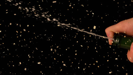 Animation-of-confetti-over-man-opening-champagne-on-black-background