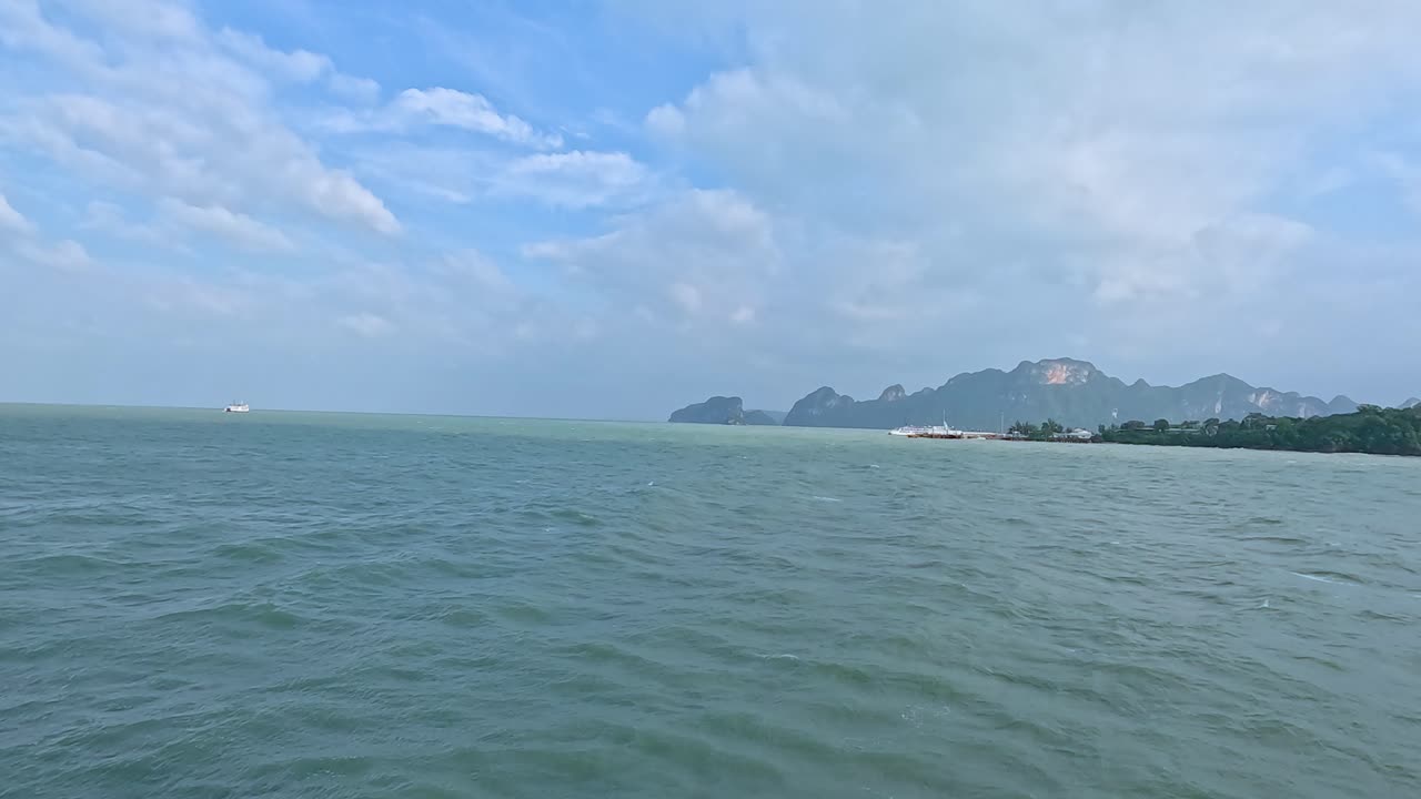Calm ocean waves and distant islands under a bright sky, captured in Koh Samui, Thailand. The camera pans smoothly across the horizon
