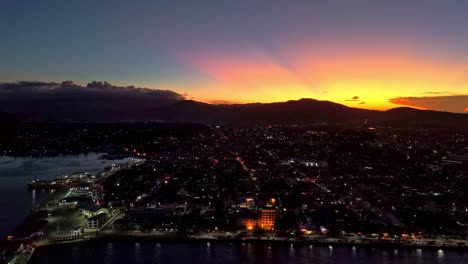 aerial de una hermosa ciudad costera con casas y pequeños edificios al atardecer con cielo naranja