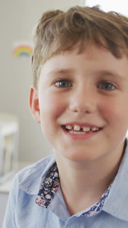 video of happy caucasian boy standing in class during lessons