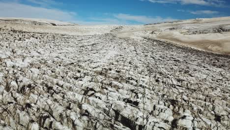 Aerial-landscape-view-over-the-textured-ice-surface-of-an-icelandic-glacier,-on-a-bright-sunny-day