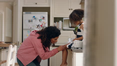 mother applying band aid to little girls knee caring for her child at home happy kid enjoying motherly love